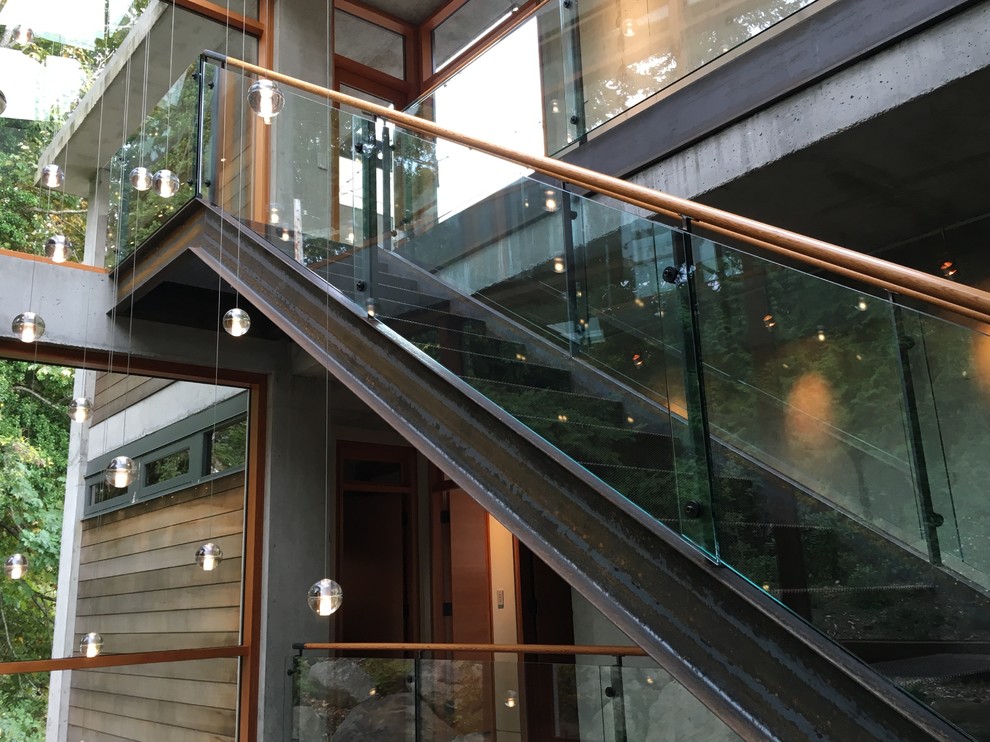 На фото: лестница в современном стиле с стеклянными перилами с