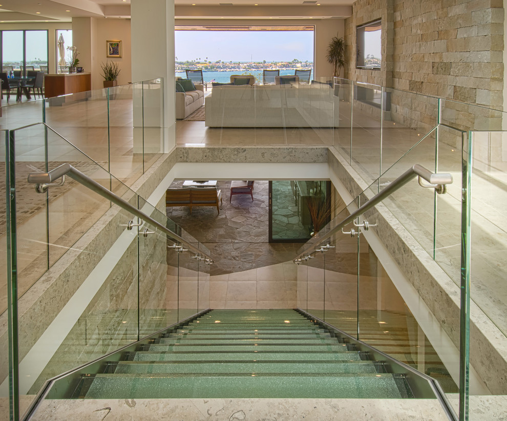 Inspiration for a large contemporary glass straight open and glass railing staircase remodel in Orange County