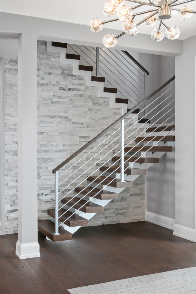 Diseño de escalera en U contemporánea grande sin contrahuella con escalones de madera, barandilla de varios materiales y ladrillo