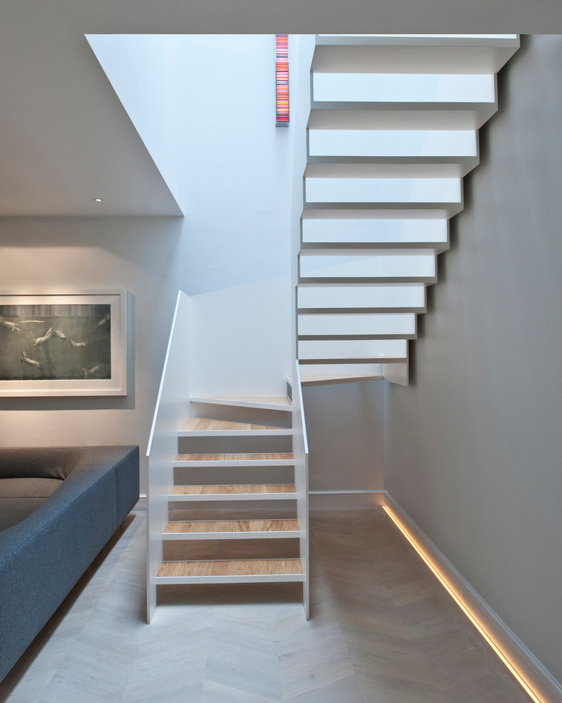 Inspiration for a modern wood u-shaped staircase in London with open risers.