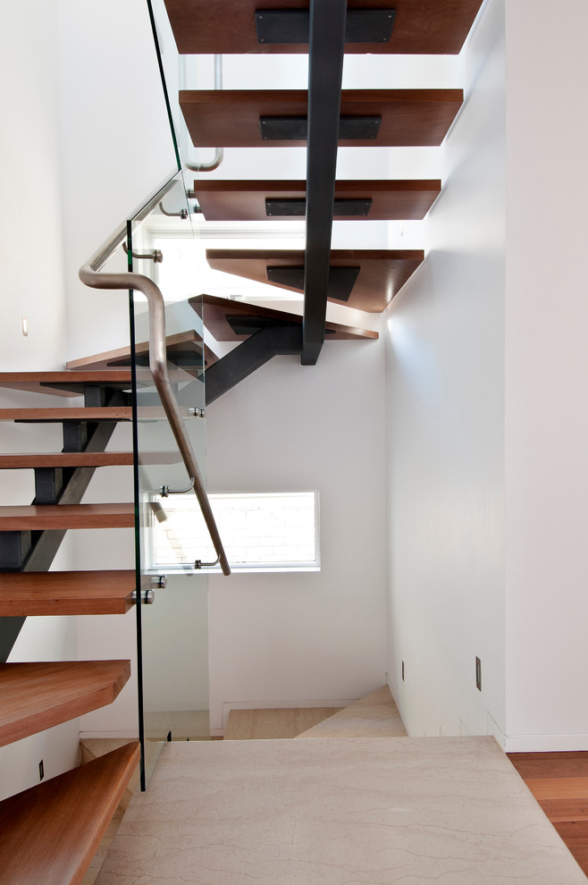 На фото: изогнутая лестница в современном стиле с деревянными ступенями без подступенок с