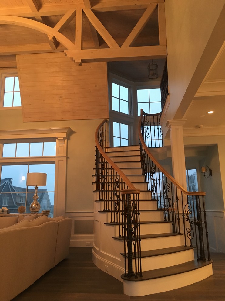 Gewendelte, Große Klassische Holztreppe mit gebeizten Holz-Setzstufen und Stahlgeländer in Boston