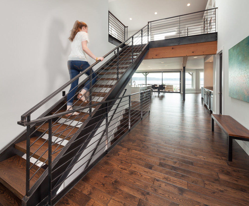 Idée de décoration pour un grand escalier sans contremarche droit design avec des marches en bois et un garde-corps en câble.