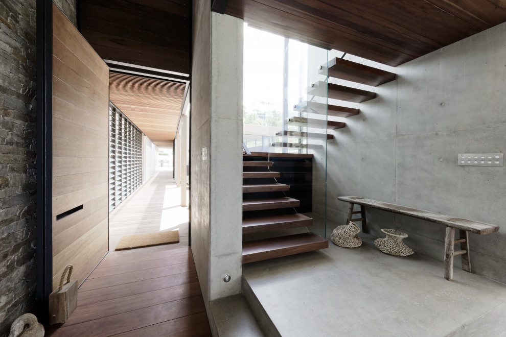 Идея дизайна: лестница на больцах, среднего размера в стиле модернизм с деревянными ступенями и стеклянными перилами без подступенок