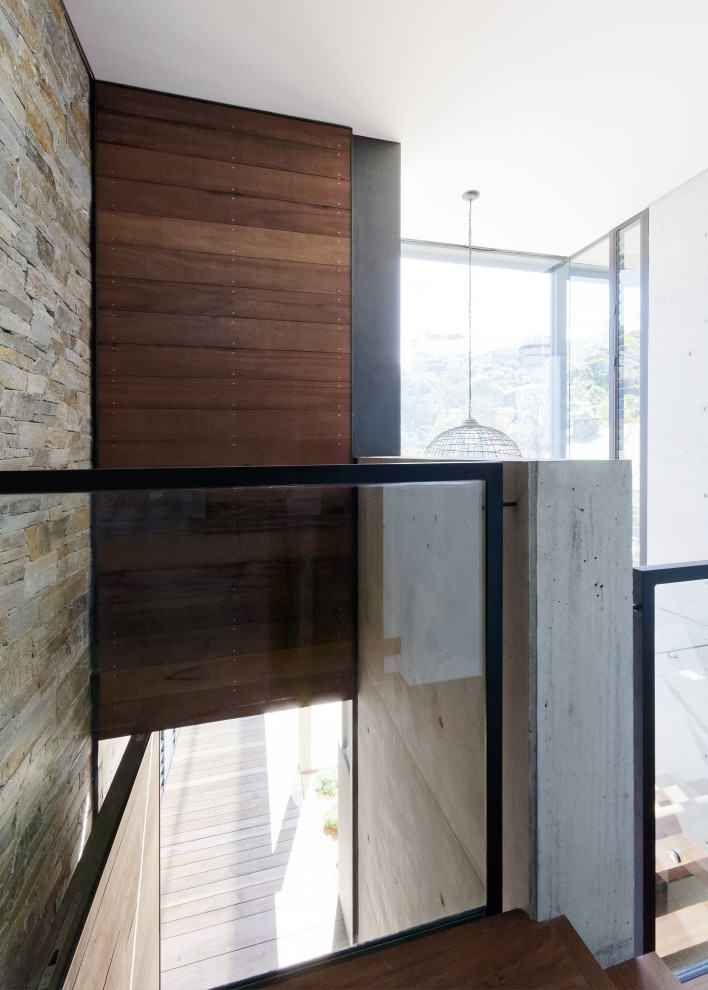 Foto de escalera suspendida minimalista de tamaño medio sin contrahuella con escalones de madera y barandilla de vidrio