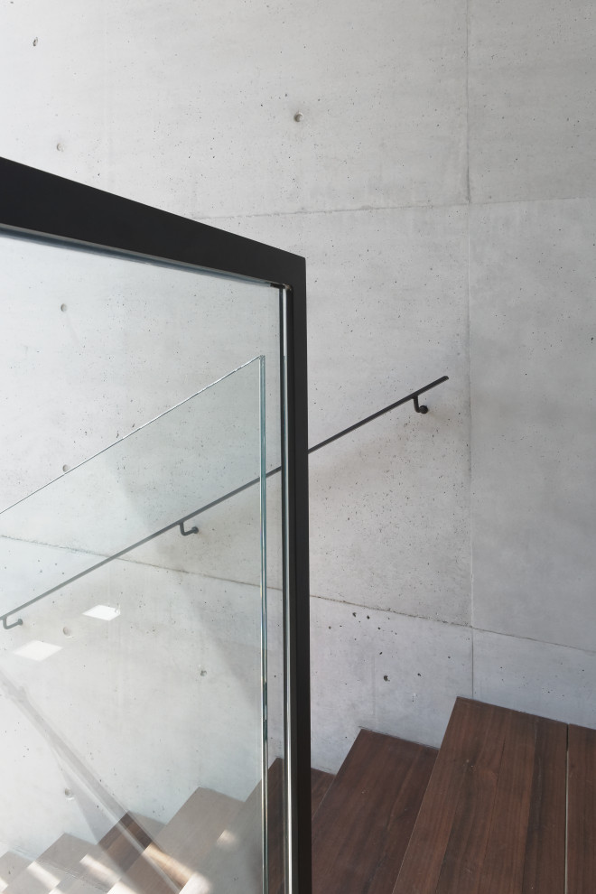 Diseño de escalera suspendida minimalista de tamaño medio sin contrahuella con escalones de madera y barandilla de vidrio