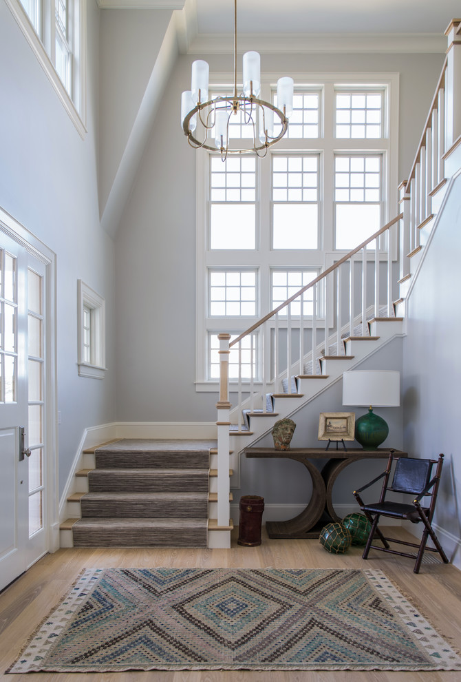 Пример оригинального дизайна: угловая лестница в классическом стиле с деревянными перилами, деревянными ступенями и крашенными деревянными подступенками