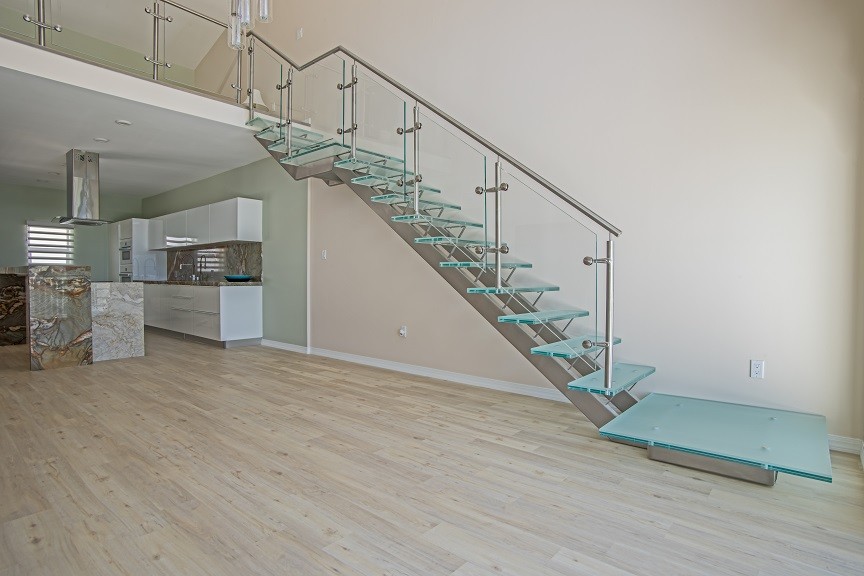 Стильный дизайн: лестница среднего размера, на больцах в морском стиле с стеклянными ступенями и стеклянными перилами без подступенок - последний тренд