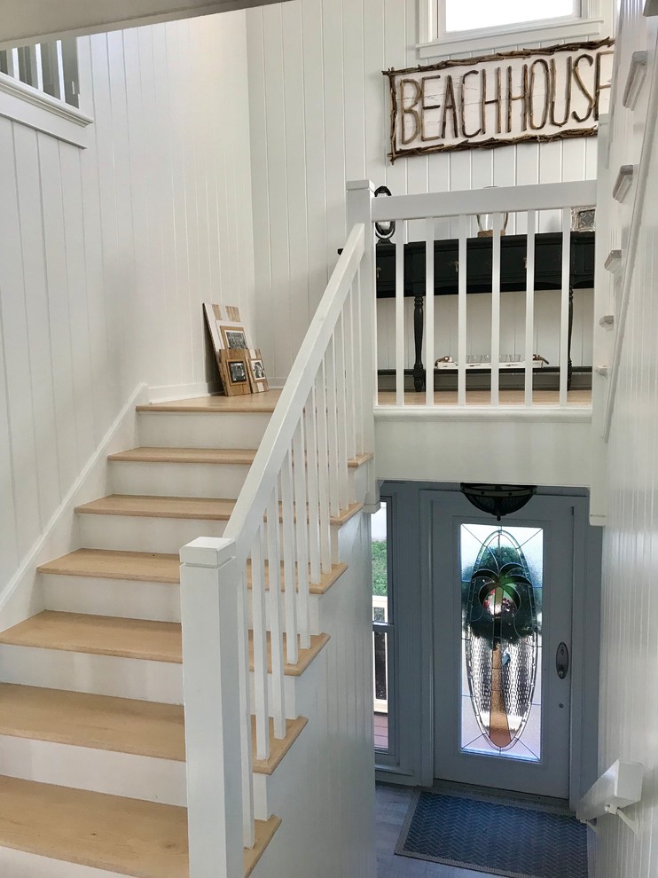 Mid-sized beach style wooden u-shaped wood railing staircase photo in Miami with painted risers
