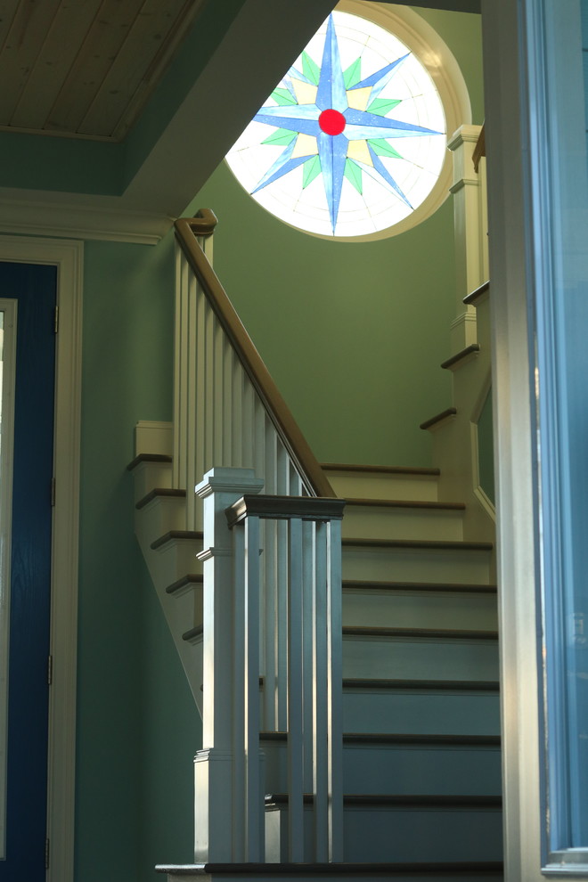 Inspiration pour un escalier peint courbe marin de taille moyenne avec des marches en bois et un garde-corps en bois.