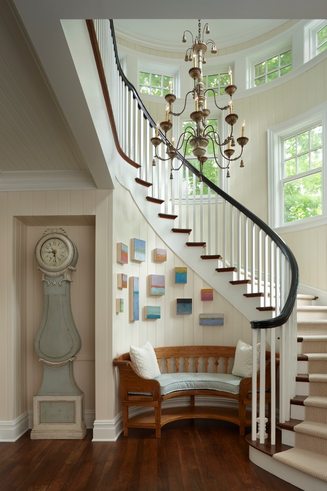 Inspiration for a large coastal wooden curved staircase remodel in Other with wooden risers