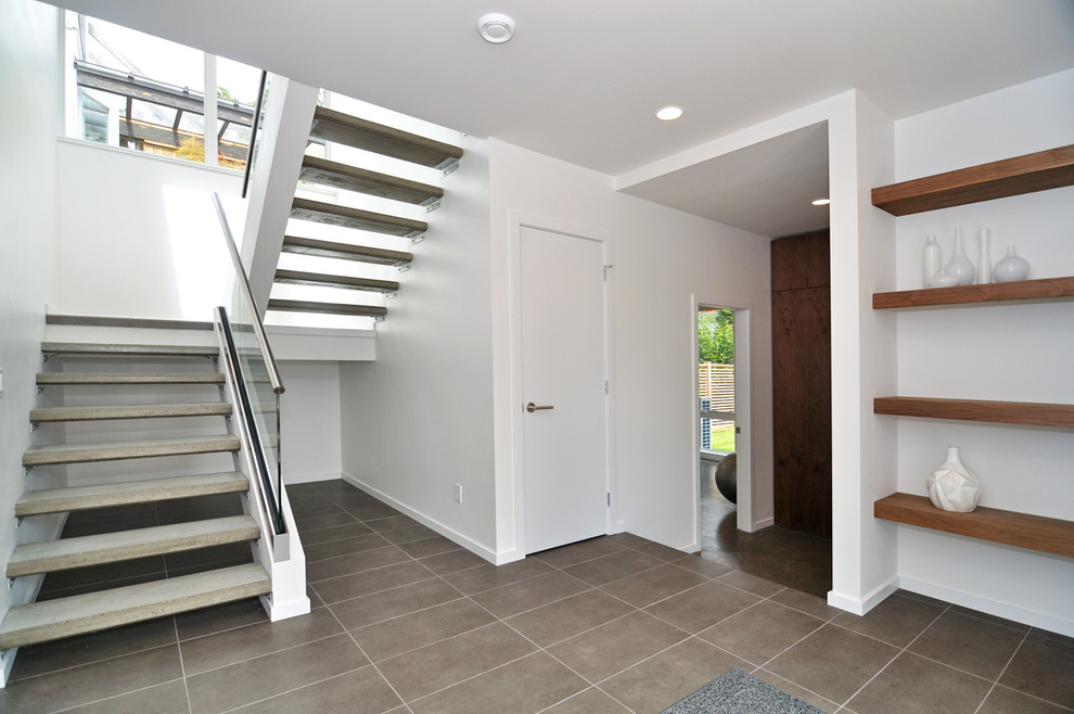 Modern concrete u-shaped staircase in Vancouver with open risers and feature lighting.