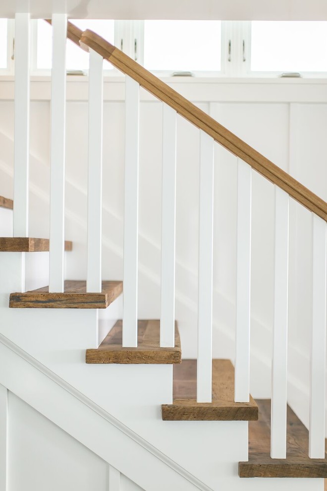На фото: прямая лестница среднего размера в классическом стиле с деревянными ступенями, крашенными деревянными подступенками и деревянными перилами