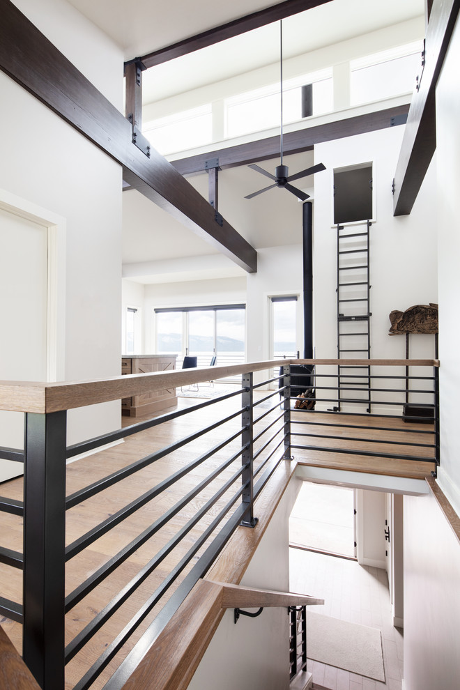 Diseño de escalera en L actual de tamaño medio con escalones de madera, contrahuellas de madera y barandilla de metal