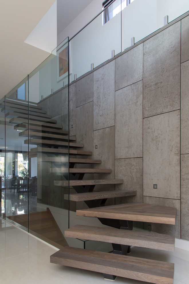 Стильный дизайн: лестница среднего размера в современном стиле с деревянными ступенями, стеклянными подступенками и деревянными перилами - последний тренд