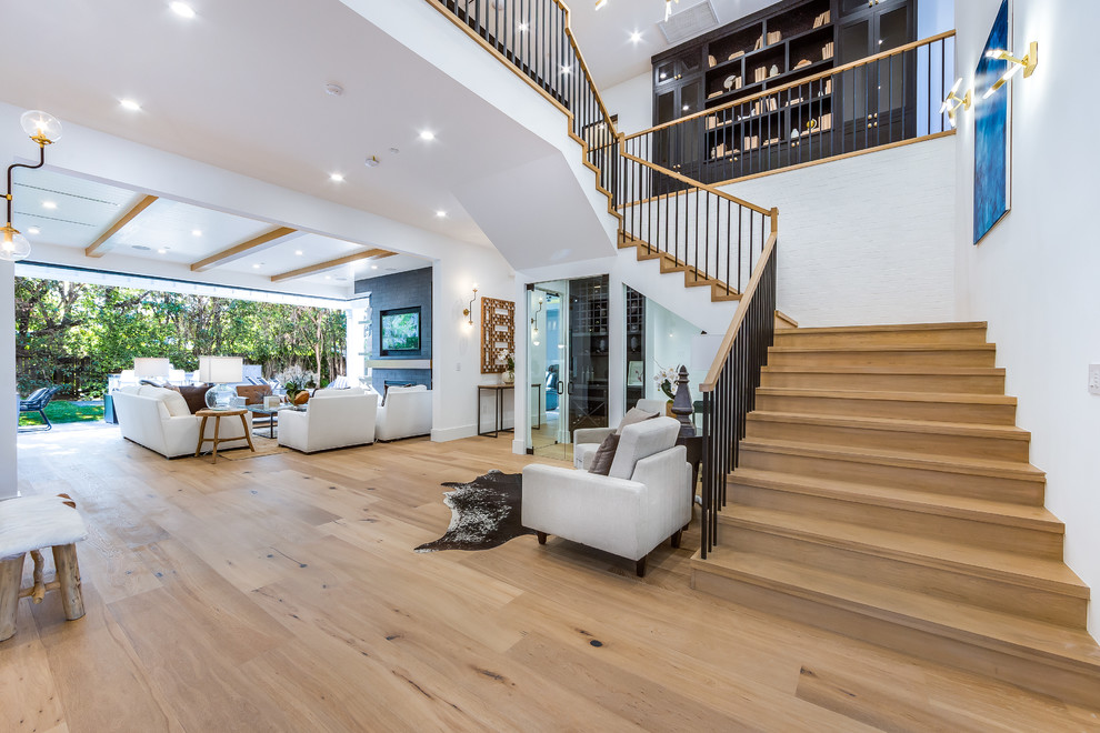 Large transitional wooden l-shaped metal railing staircase photo in Los Angeles with wooden risers