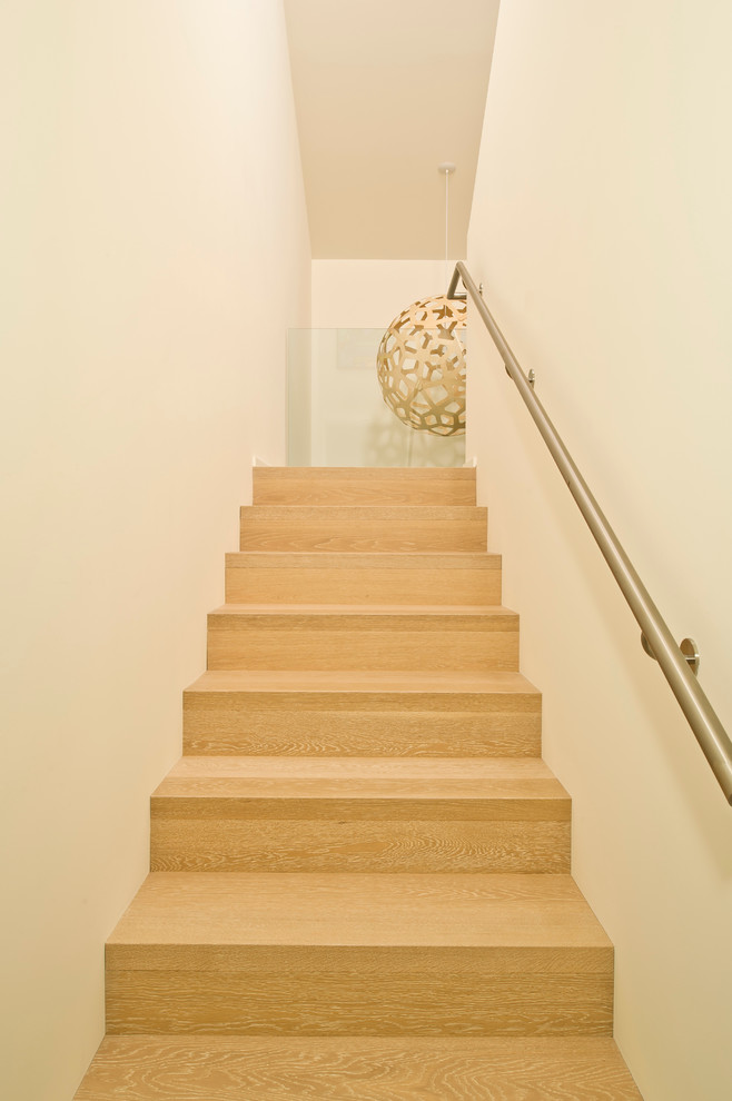 Imagen de escalera recta actual de tamaño medio con escalones de madera y contrahuellas de madera