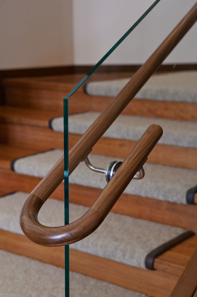 Immagine di una scala a "L" design di medie dimensioni con pedata in moquette, alzata in legno e parapetto in legno