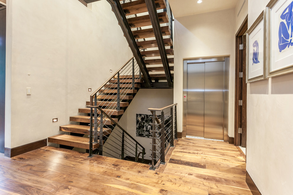 Идея дизайна: большая п-образная лестница в стиле рустика с деревянными ступенями и металлическими перилами без подступенок