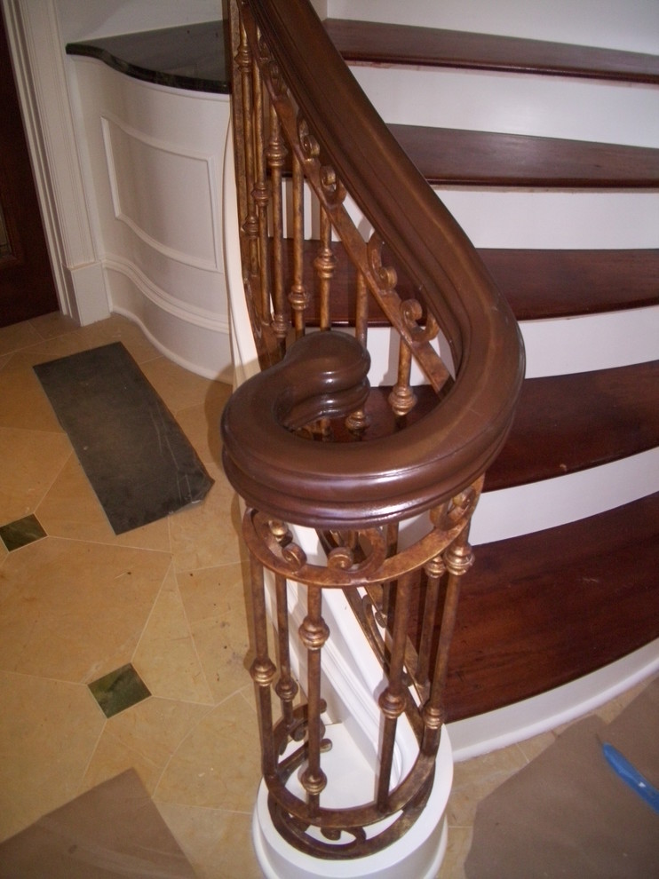 Large traditional wood floating staircase in Charlotte with wood risers.