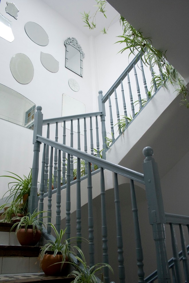 Ejemplo de escalera en U clásica con escalones de madera y contrahuellas con baldosas y/o azulejos