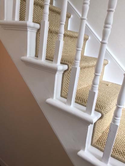 Diseño de escalera en U rústica con escalones enmoquetados, contrahuellas enmoquetadas y barandilla de madera