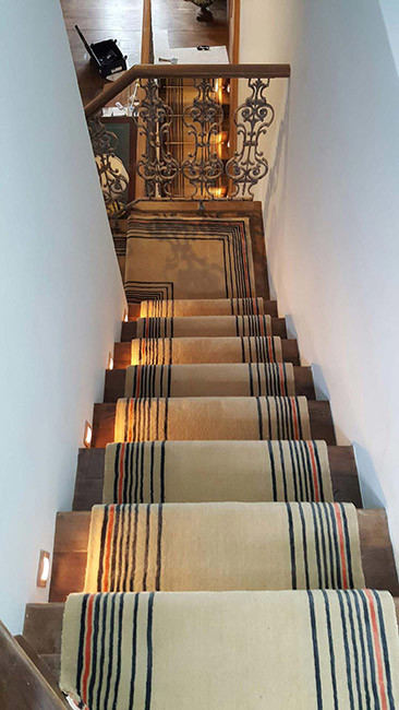 Photo of a medium sized contemporary carpeted u-shaped mixed railing staircase in London with carpeted risers.
