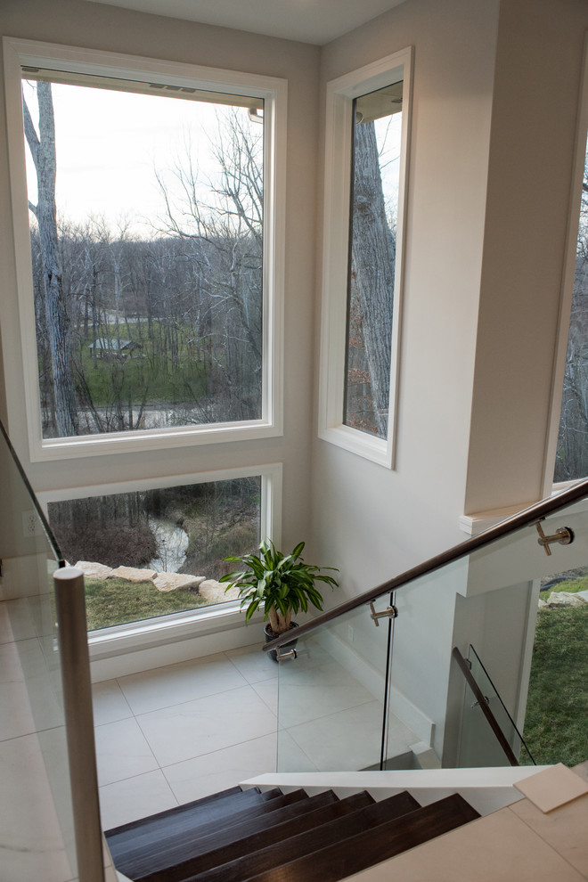 Стильный дизайн: п-образная лестница среднего размера в стиле модернизм с деревянными ступенями и стеклянными перилами без подступенок - последний тренд