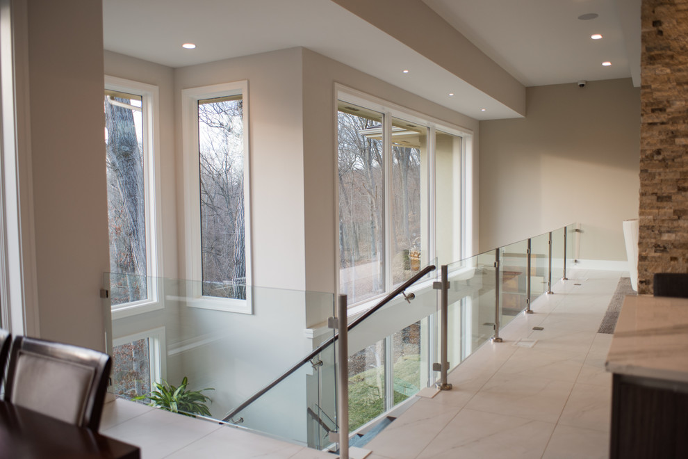 На фото: лестница среднего размера в стиле модернизм с деревянными ступенями и стеклянными перилами без подступенок