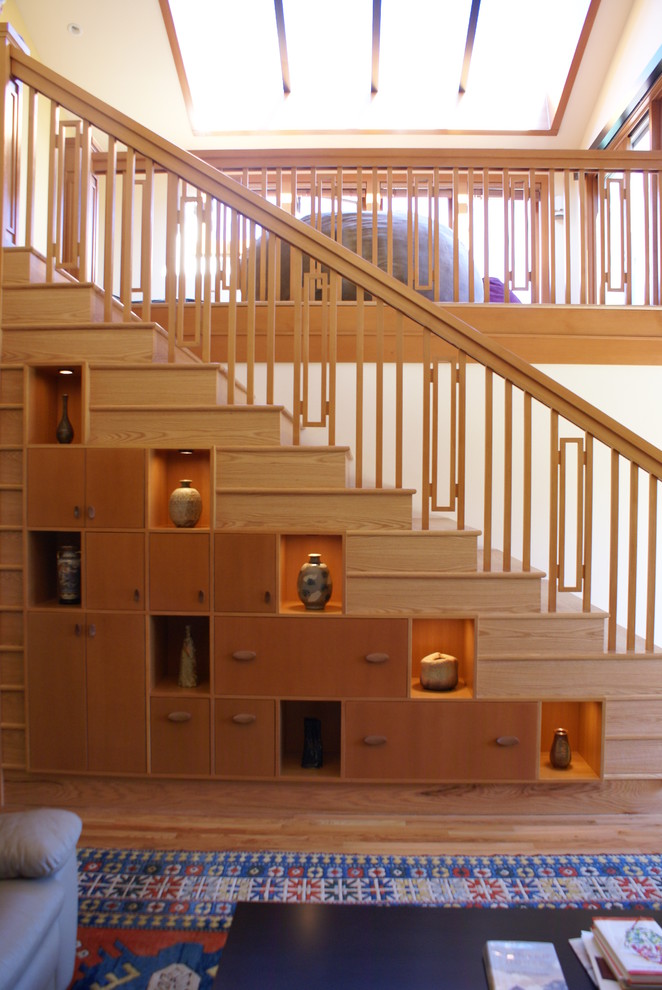 На фото: прямая деревянная лестница среднего размера в восточном стиле с деревянными ступенями и кладовкой или шкафом под ней с