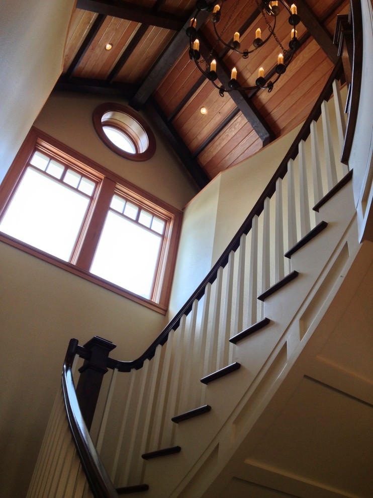 Cette image montre un grand escalier peint chalet en L avec des marches en bois et un garde-corps en bois.