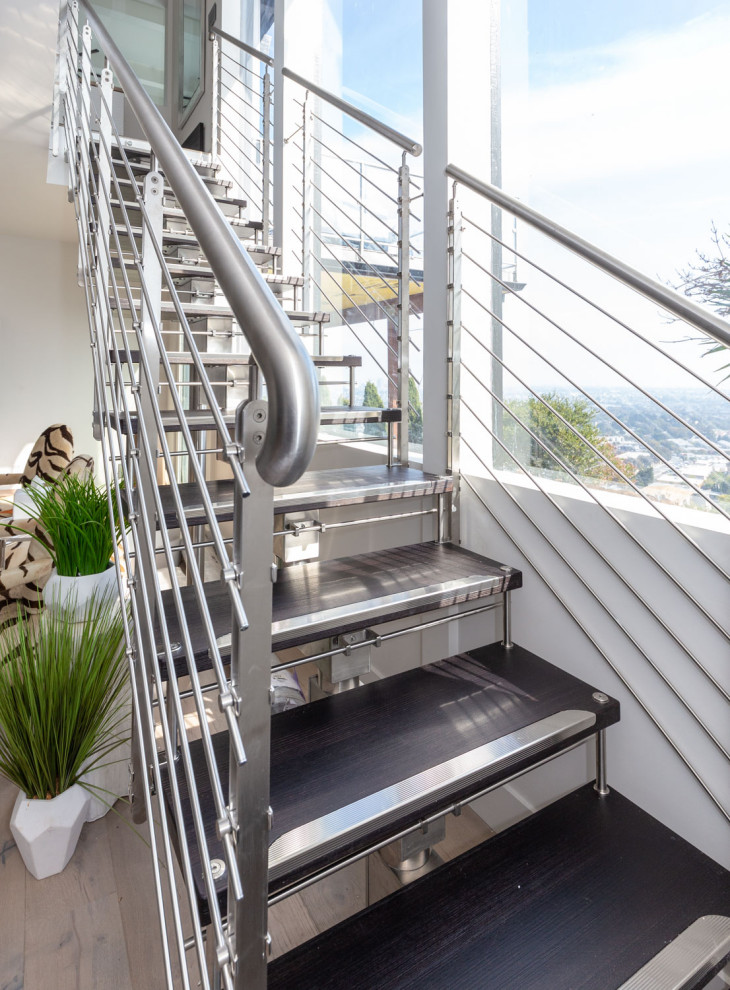 Foto de escalera recta contemporánea de tamaño medio con escalones de madera, contrahuellas de metal y barandilla de metal