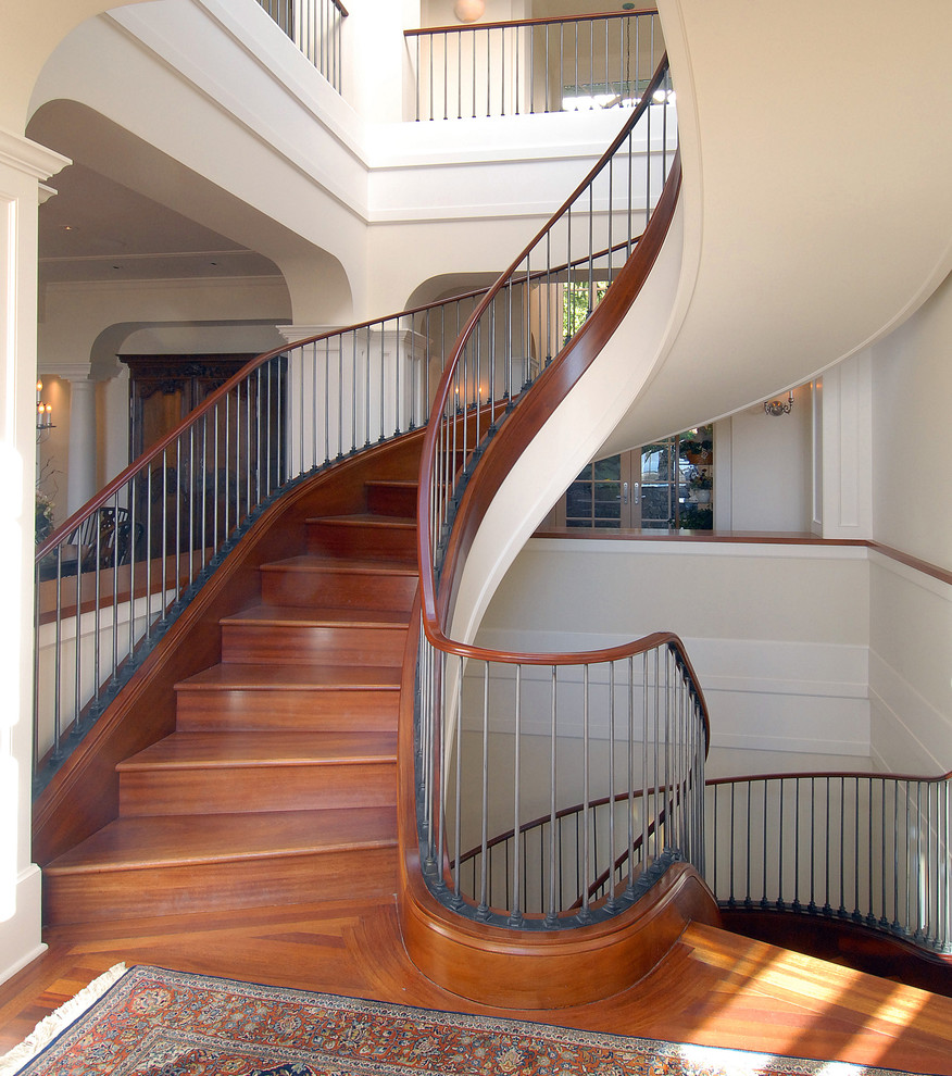 Photo of a traditional wood curved mixed railing staircase in San Francisco with wood risers.