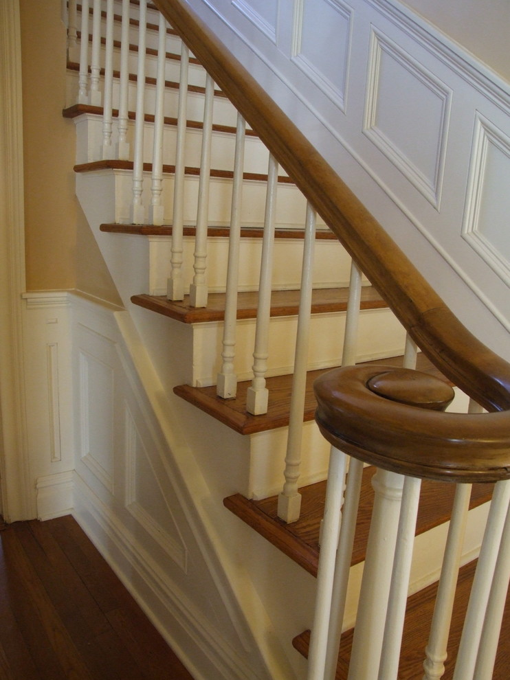 На фото: п-образная деревянная лестница среднего размера в классическом стиле с деревянными ступенями и деревянными перилами с