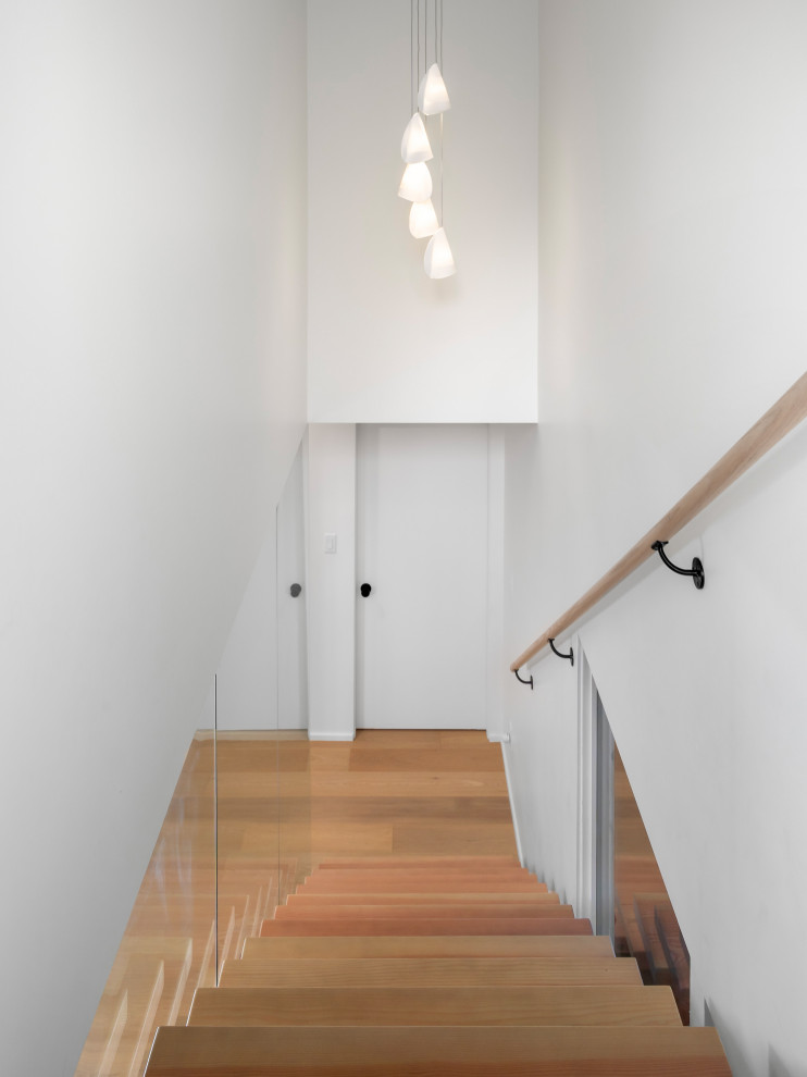 Medium sized retro wood floating staircase in Vancouver with open risers.