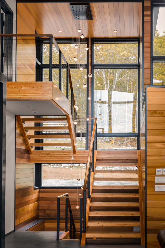 Идея дизайна: большая п-образная лестница в стиле рустика с деревянными ступенями и перилами из тросов без подступенок