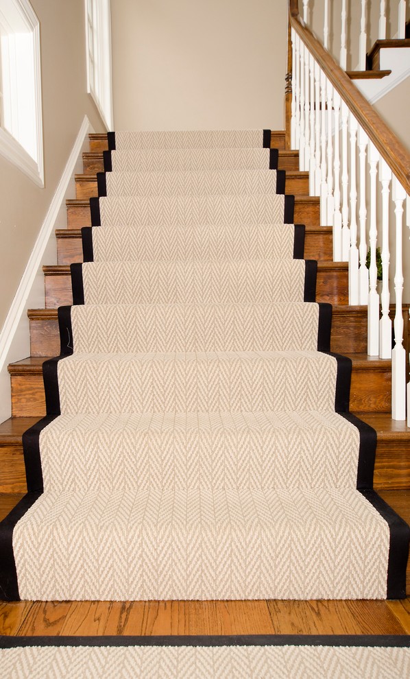 Стильный дизайн: большая угловая деревянная лестница в стиле неоклассика (современная классика) с ступенями с ковровым покрытием и деревянными перилами - последний тренд