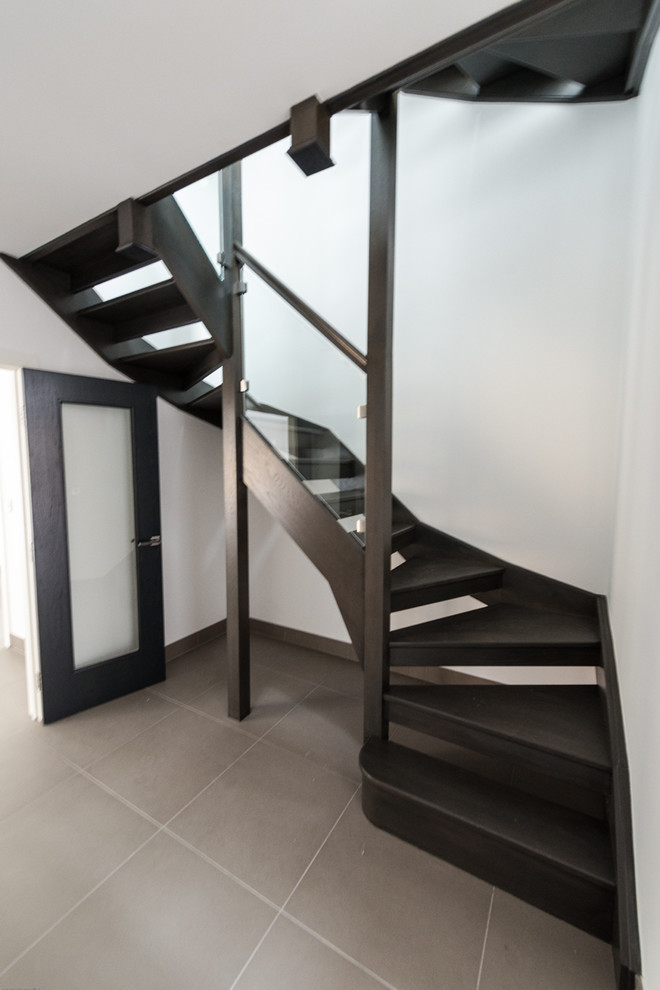 This is an example of a medium sized contemporary wood u-shaped staircase in Cambridgeshire with open risers.