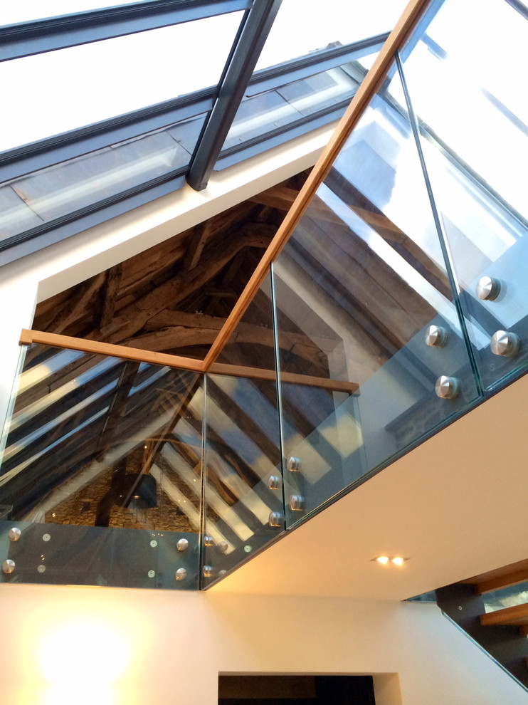 This is an example of a large contemporary wood l-shaped staircase in Hampshire with open risers.
