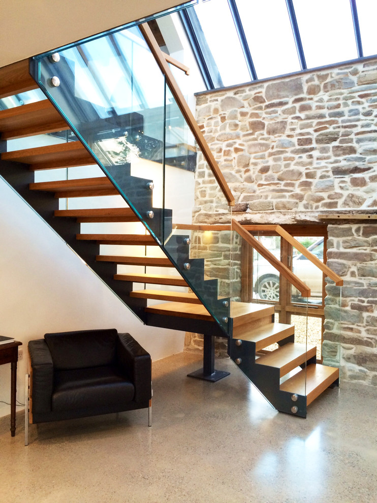 На фото: большая угловая лестница в современном стиле с деревянными ступенями без подступенок с