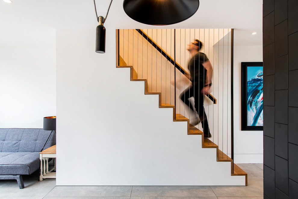 Foto de escalera recta escandinava con escalones de madera, contrahuellas de madera y barandilla de cable