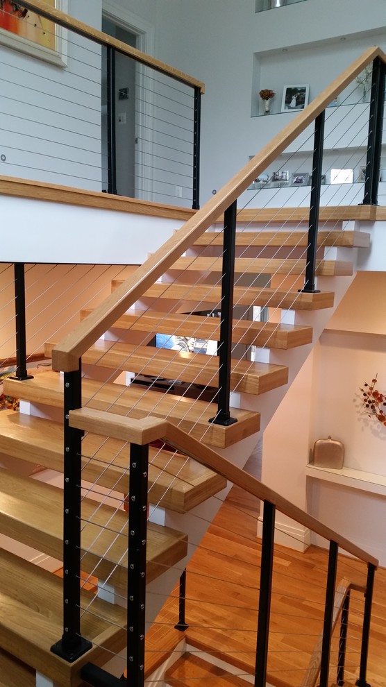 На фото: п-образная лестница среднего размера в стиле модернизм с деревянными ступенями без подступенок с
