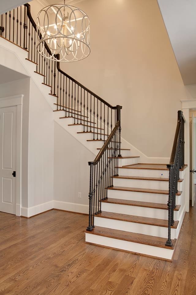 Imagen de escalera curva tradicional de tamaño medio con escalones de madera y barandilla de madera