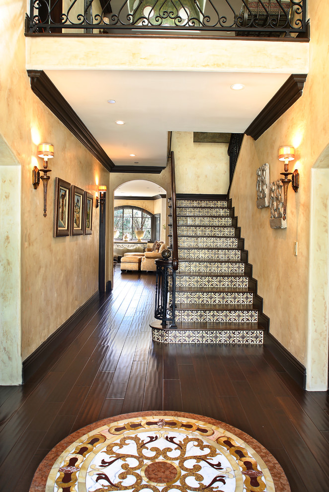 Стильный дизайн: лестница в средиземноморском стиле с деревянными ступенями и подступенками из плитки - последний тренд