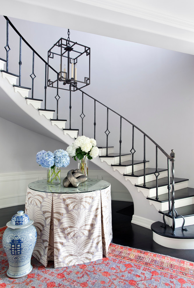 Traditional wood curved staircase in Los Angeles with painted wood risers.