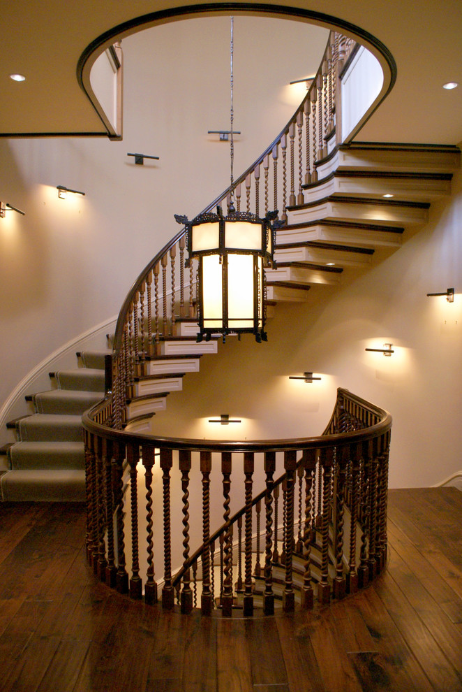 Свежая идея для дизайна: огромная изогнутая деревянная лестница в классическом стиле с деревянными ступенями - отличное фото интерьера