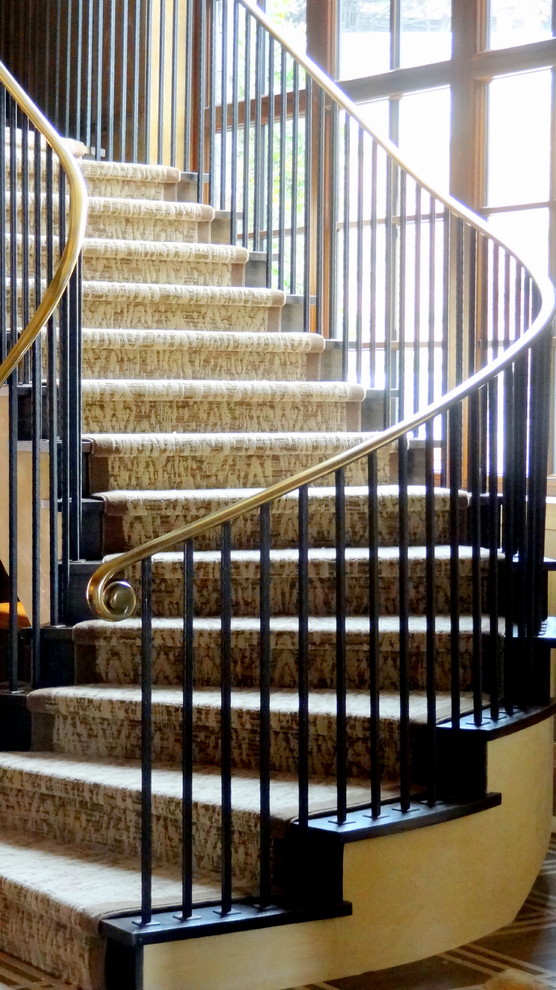 На фото: изогнутая лестница среднего размера в стиле неоклассика (современная классика) с ступенями с ковровым покрытием и ковровыми подступенками с