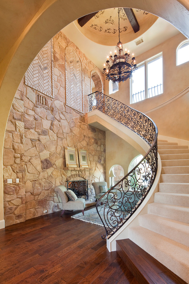 Example of a tuscan carpeted curved staircase design in Austin with carpeted risers