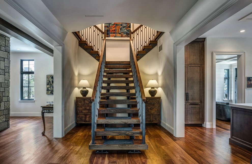 Aménagement d'un escalier sans contremarche classique avec des marches en bois, un garde-corps en matériaux mixtes et éclairage.