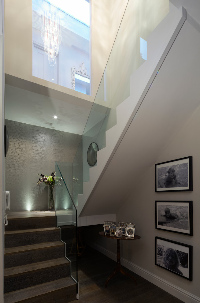 Photo of a medium sized contemporary wood u-shaped staircase in London with wood risers and feature lighting.